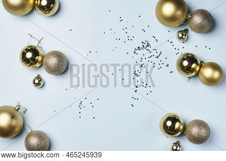 Some Gold Christmas Balls And Confes On A White Background With Confectional Confection In The Middl