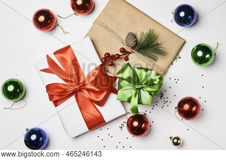 Christmas Decorations And Presents On A White Background With Red, Green And Blue Baknots Around The