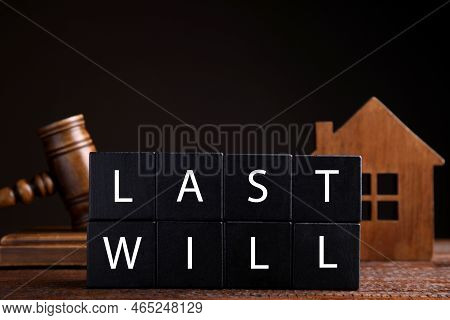 Black Cubes With Words Last Will On Wooden Table Against Dark Background