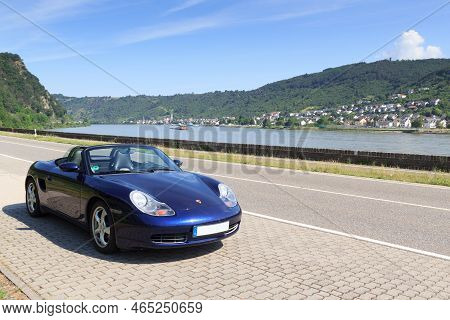 Bad Salzig, Germany - June 26, 2021: Blue Roadster Porsche Boxster 986 With River Rhine Gorge Panora