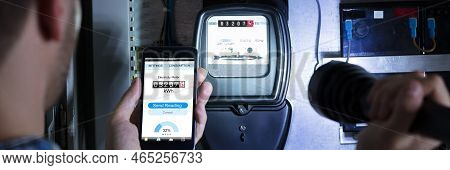 Electrician Reading Energy Meter Using Mobile Phone