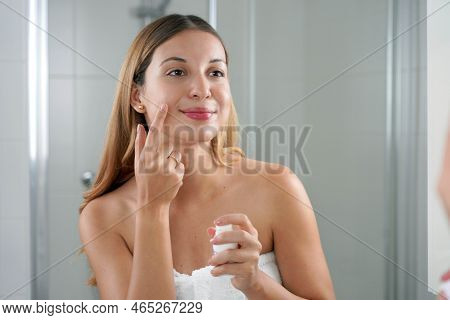Skin Care Woman Applying Cream With Retinol Anti-signs In The Bathroom