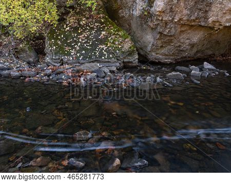 Shoreline Rocks, Autumn Foliage, Stream Rocks And Other Details Contrast With Streaking Foam Dots Cr
