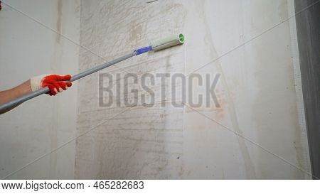 The Process Of Applying A Primer With A Roller. The Process Of Applying A Primer To A Wall Using A R