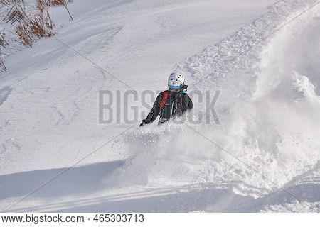 Valmorel, France - Circa, 2019: Snowboarder In Deep Snow Free Ride Coming Down The Slope After Heavy
