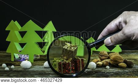 Chritmas Decoration With Copy Space On Rustic Wood With Hand Holding Loupe Upfront Gifts Box