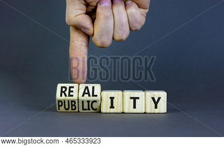 Reality Or Publicity Symbol. Businessman Turns Wooden Cubes And Changes The Word Publicity To Realit