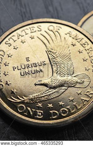 American Coins Closeup Lie On Dark Surface Of Office Table. Soaring Eagle Sacagawea Dollar Coin. Us 