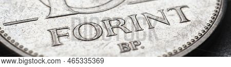 Hungarian Coin Of 10 Forints Lies On Textured Surface Close-up. Money Of Hungary. News About Economy