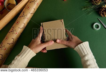 Top View Female Hands Holding A Cardboard Box, Packing Gifts For Christmas Or New Year Event, On A G