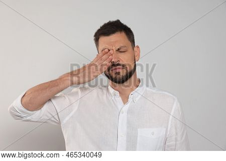 Man Suffering From Eyestrain On Light Background