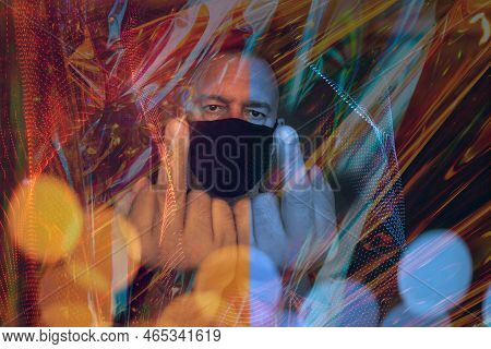 Man Making An Obscene Sign With Both Hands With His Face Covered With A Mask Overlaid With Lights An