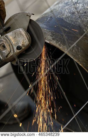 Shallow Depth Of Field (selective Focus) Details With A Worker Using An Angle Grinder On An Industri
