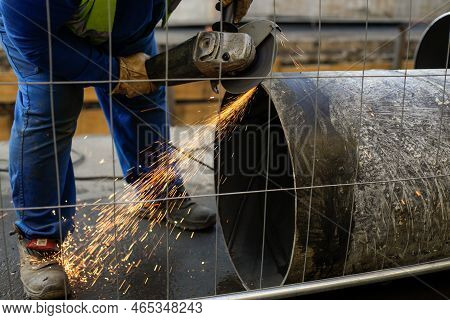 Shallow Depth Of Field (selective Focus) Details With A Worker Using An Angle Grinder On An Industri