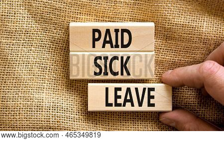 Paid Sick Leave Symbol. Concept Words Paid Sick Leave On Wooden Blocks. Doctor Hand. Beautiful Canva