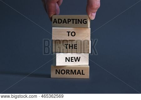 Adapting To The New Normal Symbol. Wooden Blocks With Words Adapting To The New Normal On Beautiful 