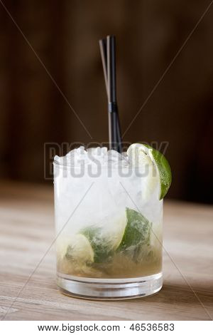 Caipirinha cocktail met rietjes zittend op een tafel wodden.