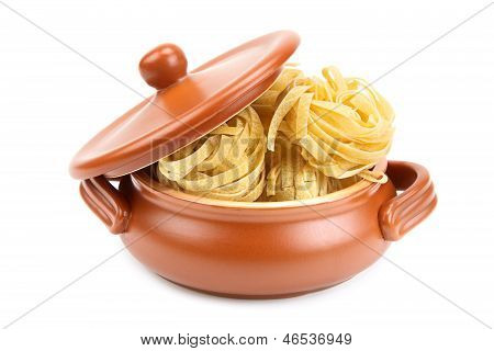 Spaghetti i en lerkrukke, isoleret på hvid baggrund