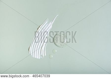 Cosmetic Smear And Drops On Colored Background Top View. Self Care Concept.