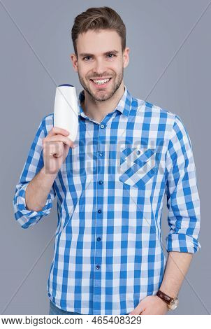 Unbranded Cosmetic For Cheerful Man. Stylish Man Hold Bottle Of Unbranded Cosmetic.