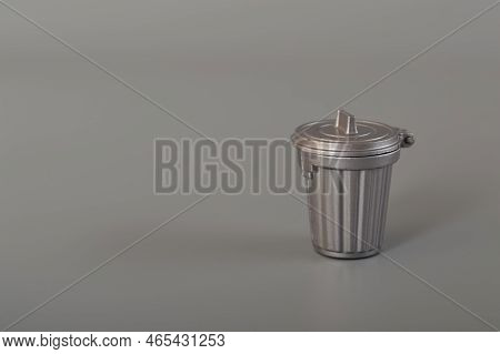 Grey Trash Can Isolated On A Grey Background. Copy Space For The Text.