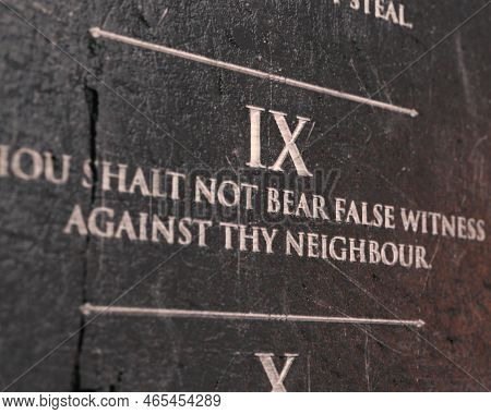 A View Of The Ninth Commandment Etched Into A Cracked Stone Tablet On An Isolated Background - 3d Re