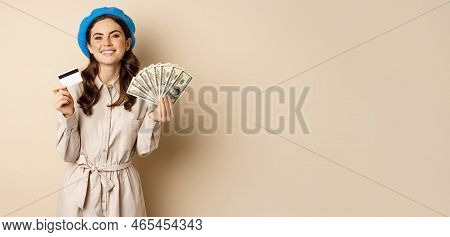 Microcredit And Money Concept. Young Stylish Woman Showing Credit Card And Dollars Cash, Smiling Hap