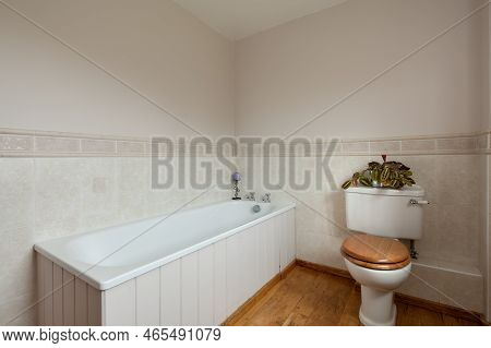 Fen Ditton, England - Jan 10 2019: Simple Partially Tiled Bathroom With Panelled Bath And Toilet.