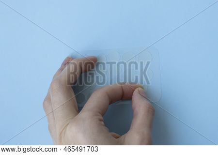 The Girl Tears Off The Sticker. Round Prosaic Acne Patches. Skin Care At Home