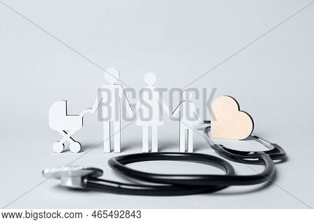 Figures Of Family Stainding Near Stethoscope On White Background. Insurance Concept