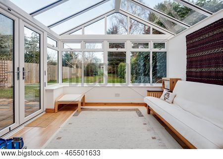 Cambridge, England - Jan 15 2019: Upvc White Garden Room Conservatory Furnished With White Sofa And 