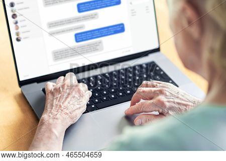 Chat Messages In Laptop Of An Old Woman. Love Fraud Scam Of Catfish. Elder Person In Online Conversa