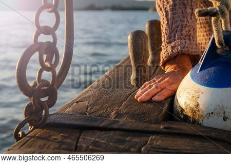 Close Up Of Wrinkled Sailor Hand, Sailing Into The Sunset. Experienced Marine Sailing At Sea