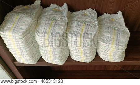 White Baby Diapers Stacked On The Shelf.