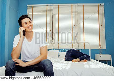 Handsome Asian Flirt Secretly Chatting With Others On His Smartphone Is Having A Friendly Chat While