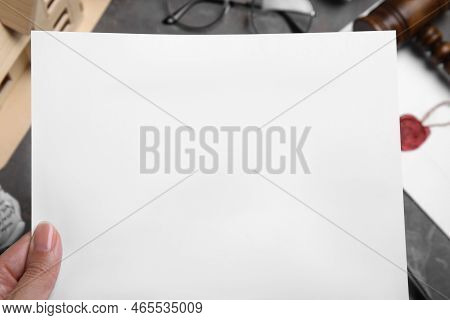 Woman Holding Last Will And Testament At Grey Table, Closeup