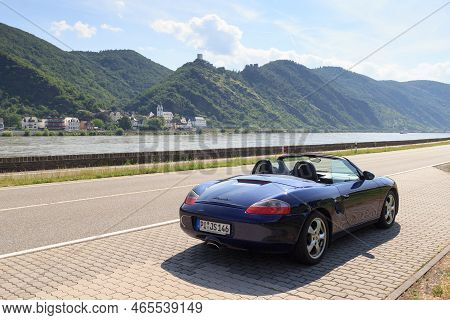 Bad Salzig, Germany - June 26, 2021: Blue Roadster Porsche Boxster 986 With River Rhine Gorge And Ca