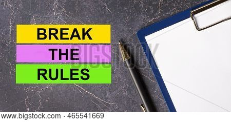 On A Dark Marble Background, A Tablet With Paper, Pen And Three Bright Multi-colored Strips Of Paper