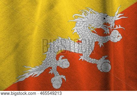 Kingdom Of Bhutan National Flag On Background.