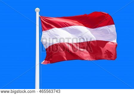 Austria Flag Waving Against Clean Blue Sky, Close Up. Austria Flag In The Blue Sky. Flag Austria On 