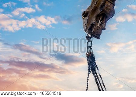 Steel Chain Attached To The Excavator's Arm. Lifting Gear Against Blue Sky With Space For Text As An