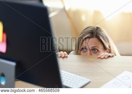 Scared And Shocked Woman In Panic Behind Desk Looking At Computer Screen. Getting Bad News, Watching