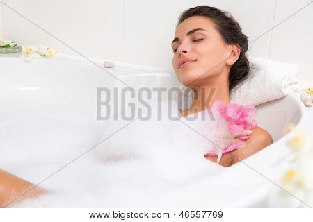 美丽的年轻女子花泡泡浴