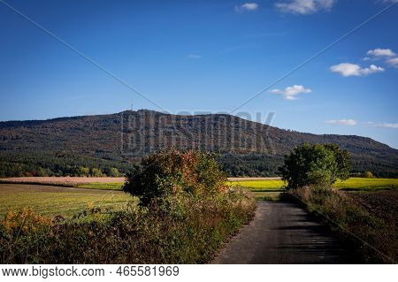 View To Sleza Mountain In Poland. A Path In The Countryside, Surrounded With Trees And Yellow Canola