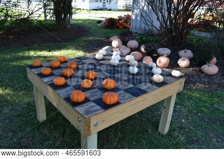 A Chessboard With Orange And White Pumpkins