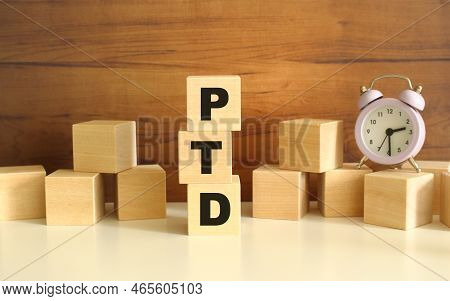 Three Wooden Cubes Stacked Vertically On A Brown Background Make Up The Word Ptd. Cubes Are Scattere