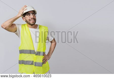 Worried Builder Engineer Holding His Head. Worried Engineer Man Looking Up. Troubled Young Engineer