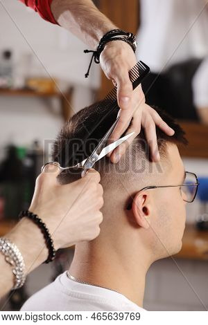 Hands Of Barber Using Scissors To Cut Customer's Hair In Salon. Barber Cuts Hair, Hairstyle. Male Cu