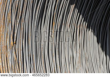 Steel Wire Wound On A Spool. Slightly Rusty, Thick, Steel Wire Rolled Into A Cylindrical Roll .