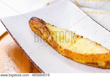 Baked Ripe Plantains With Cheese (plantain Canoe Or Platanos Asados Con Queso) On A Plate On Wooden 